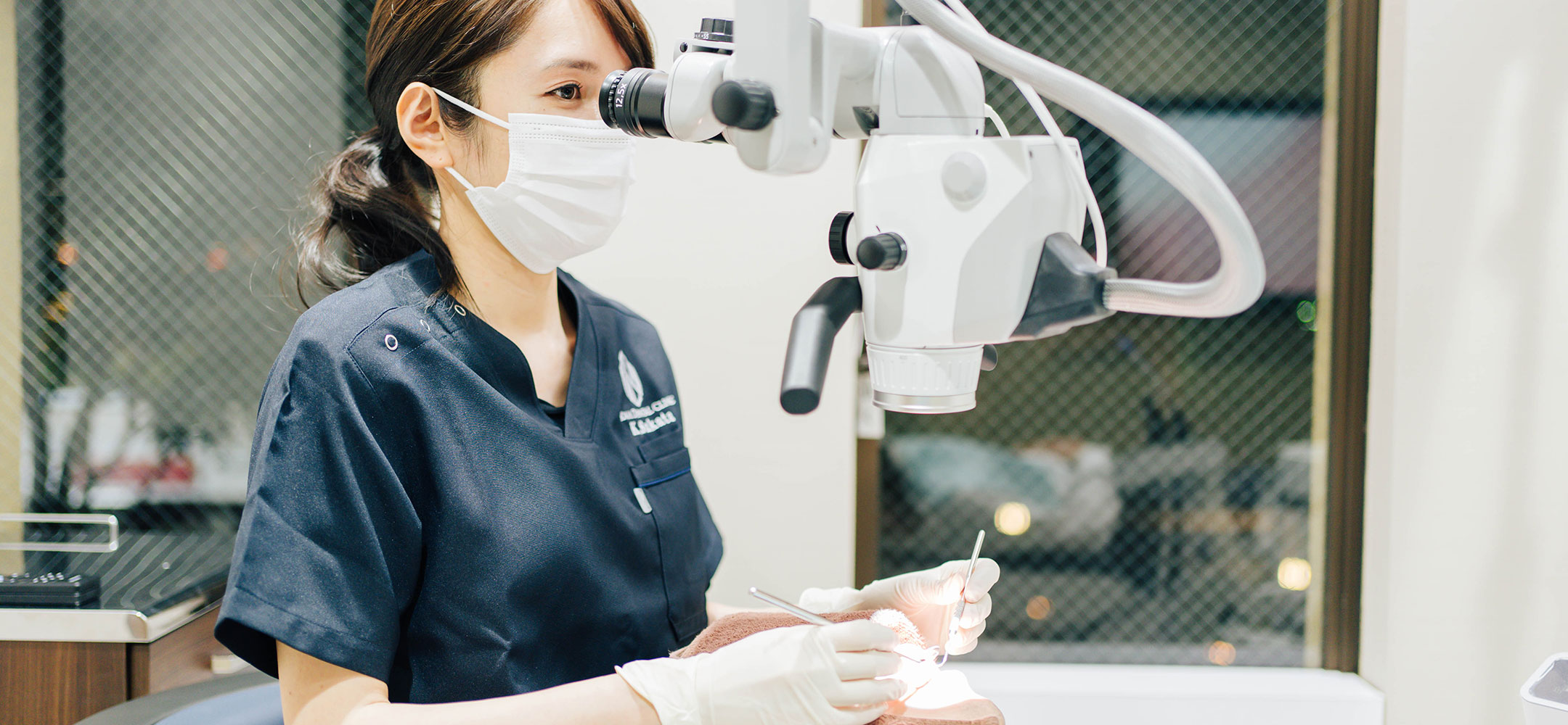 歯科用マイクロスコープを使用して診療する歯科医師